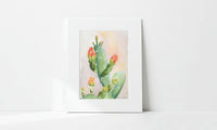 Matted artwork of a cactus with red flowers on a white background