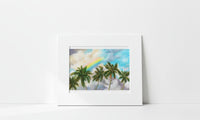 Matted artwork of palm trees and a rainbow on a white background