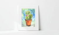 Matted artwork of a cactus with a colorful background on a white surface
